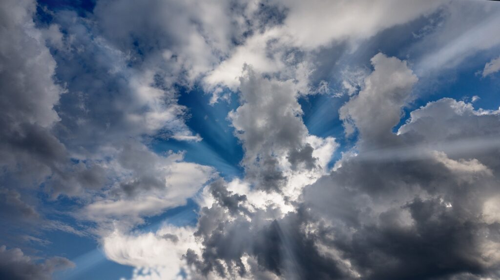 雲の切れ間から差し込む神秘的な光。希望や導きを感じさせる風景